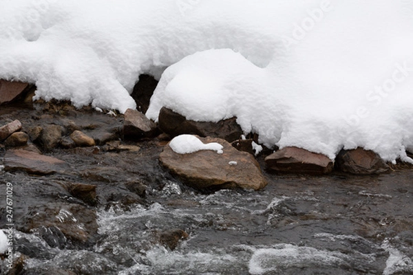 Obraz river with rocks and snow on the bank