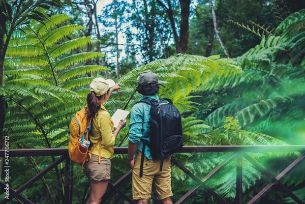 Fototapeta Asian couple travel nature walking relax and studying nature in the fores...