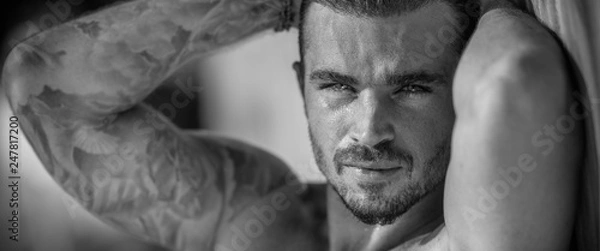 Fototapeta Portrait of a handsome caucasian male model posing on the beach