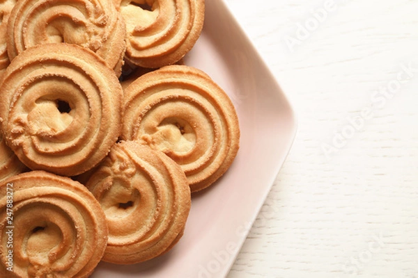 Fototapeta Plate with Danish butter cookies on wooden table, top view. Space for text
