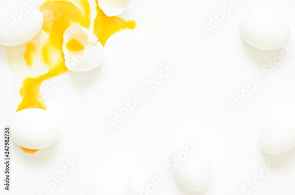 Fototapeta Eggs.  Eggs fresh, unharmed and one broken egg with yellow yolk on a white background. Healthy eating concept of produce organically grown.