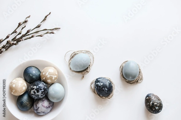 Fototapeta Pastel composition for the holiday of Easter. Colored eggs in natural colors. Background for the presentation of work or text. Top view. Copy space.  Mock-up