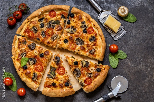 Fototapeta pizza with tomatoes, cheese, mushrooms, olives and spinach on a dark background