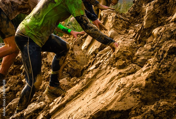 Fototapeta Muddy obstacle race runner in action. Mud run