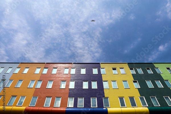 Fototapeta A colorful building like a rainbow in Amsterdam, Netherlands. This photo also includes blue and cloudy sky.