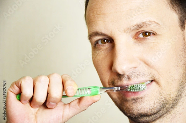 Obraz young man brushing his teeth