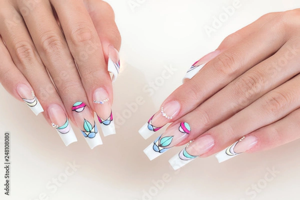 Obraz Manicure on nails isolated on cream background. Manicure with gems and sparkles. Trendy Accessories. Beauty hands. Stylish Nails