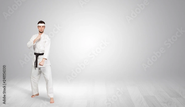 Fototapeta Young kung-fu trainer fighting in an empty space
