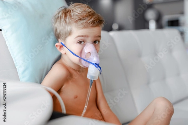 Obraz sick boy in nebulizer mask making inhalation, respiratory procedure by pneumonia or cough for child, inhaler, compressor nebulizer, nebules machine for health care.