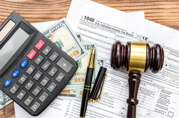 Fototapeta Gavel with calculator and money  on tax form. Top view. Tax law.