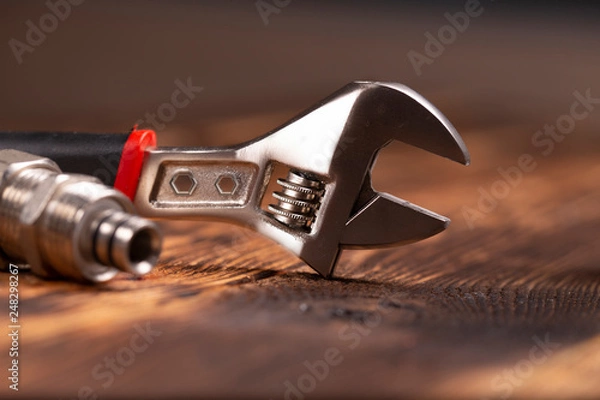 Obraz closeup of adjustable wrench and coupling. fitting 1/2.Nice blurring background.