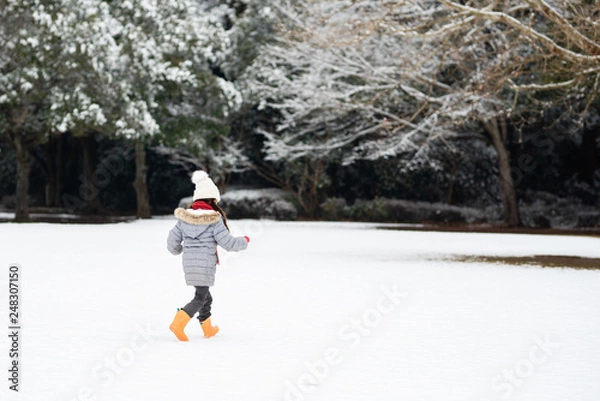 Fototapeta 雪の積もった公園で遊ぶ女の子