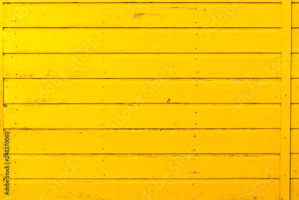 Fototapeta Section of yellow wood panelling from a seaside beach hut. Perfect as a background for Summer Holiday or seaside themes.