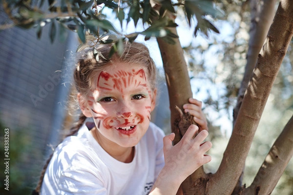 Fototapeta Cute girl with face cat make up on birthday smiling roaring like small tiger