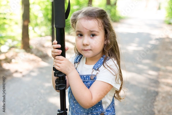 Fototapeta Hobby, profession, children and photographer concept - child with camera in forest