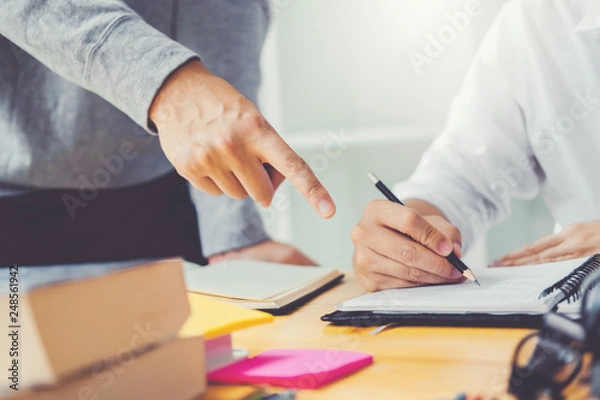 Fototapeta High school or college students studying and reading together in library