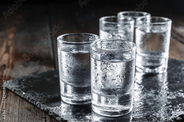 Obraz Vodka in shot glasses on rustic wood background