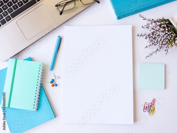 Obraz Home office workspace mockup.Workspace top view, copy space.White desk office with blank notebook, computer and other office supplies. Flat lay, top view office table desk.Minmal workspace.