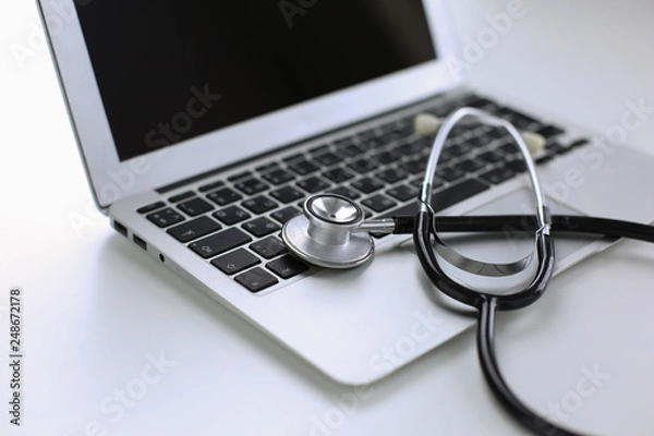 Fototapeta Stethoscope lying on a laptop keyboard in a concept of online m