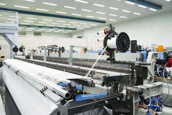 Fototapeta Weaving automatic machines - Weaving is a method of textile production in which two distinct sets of yarns or threads are interlaced at right angles to form a fabric or cloth.