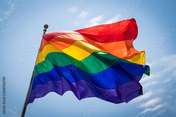 Obraz The Rainbow Pride Flag Blows in the Breeze against the Blue Sky over the San Diego LGBT Pride Parade in the Hillcrest Neighborhood