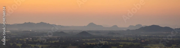 Fototapeta Panorama or wide angel view of small city in front of the mountains in Thailand with beautiful evening sky.