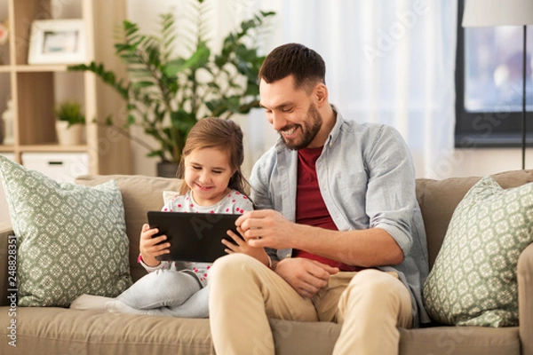 Fototapeta family, fatherhood and technology concept - happy father and little daughter with tablet pc computer at home