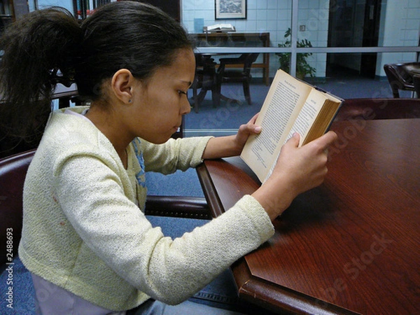 Fototapeta child reading in the library