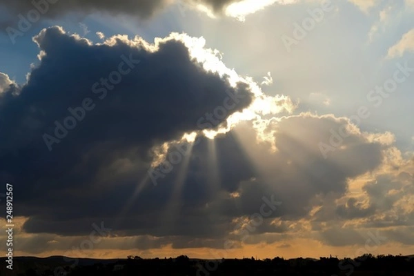 Obraz Dramatic cloudy sunset landscape with sun rays in Negev desert.