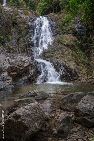 Fototapeta Landscape with an idyllic waterfall in the rainforest and a natural pool