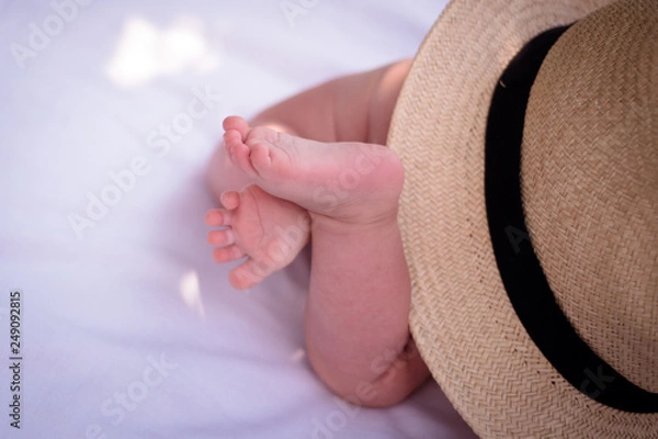 Fototapeta Baby's feet and the sun hat