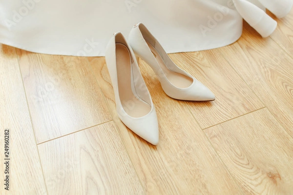 Obraz White shoes for the bride on a wooden background