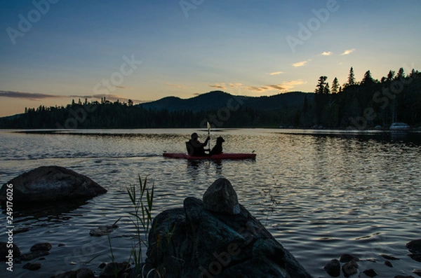Obraz silhouette of man and dog in kayak at sunset