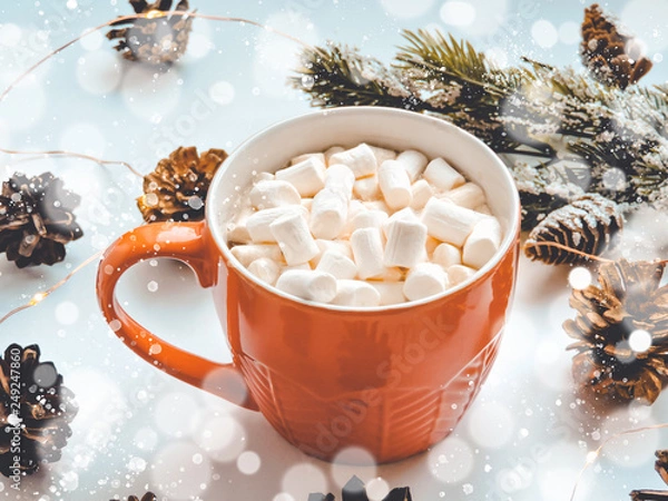 Obraz Orange mug with hot chocolate with melted marshmallow.Holiday concept. Flat lay, top view.ot cocoa with marshmallow in a  mug surrounded by winter things.Christmas hot beverage ideas.