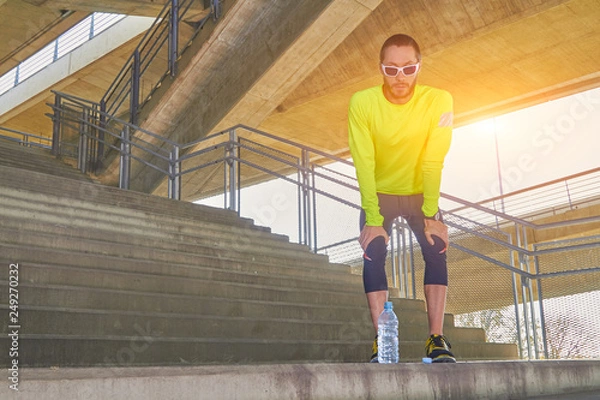 Fototapeta Sportsman working out / jogging on a big city urban bridge.