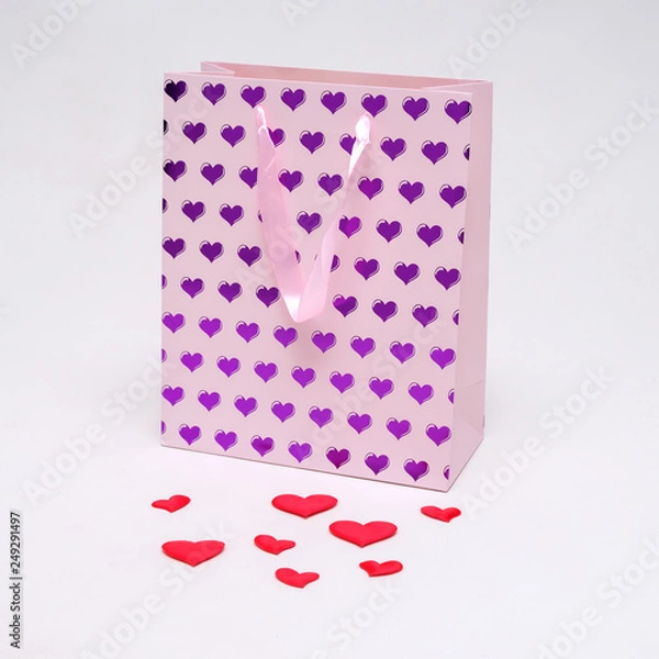 Fototapeta Concept on a white background of Saint Valentine heart of pink color on a package from the store.