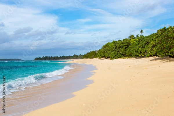 Fototapeta Shore of an azure, turquoise, blue lagoon. Waves, surf, swash at a remote empty idyllic sandy beach on Foa island, Haapai (Haʻapai or Ha'apai) group, Tonga, Oceania, South Pacific Ocean. Near Lifuka.
