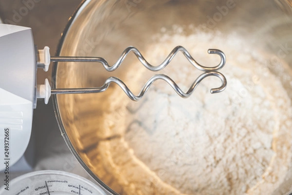 Fototapeta Brot backen mit Mehl, Wasser und den Knethaken eines Handrührgeräts.