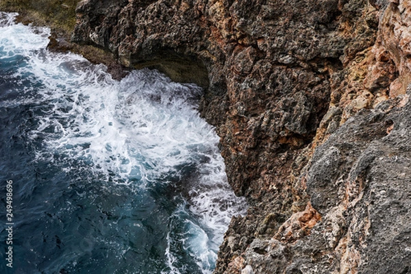 Fototapeta Aerial view of sea waves and fantastic Rocky coast, Danger sea wave crashing on rock coast with spray and foam before storm