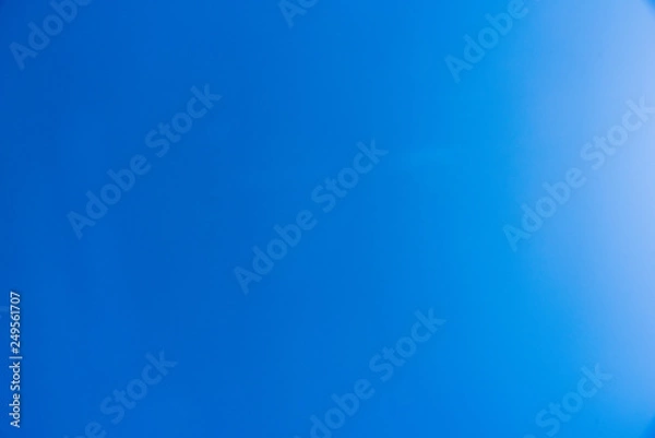 Fototapeta Clear blue sky empty with a sun reflection on one side - empty space for design