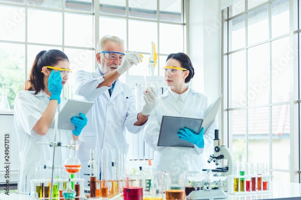 Fototapeta Science teacher and students team working with chemicals in lab