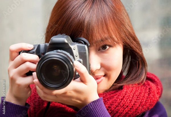 Fototapeta Female photographer using SLR camera.