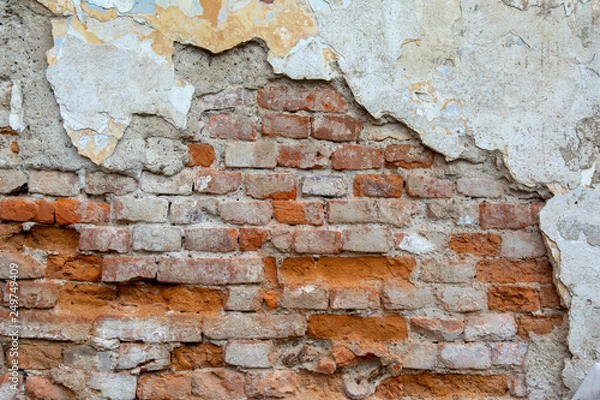 Fototapeta red brick wall with old falling plaster. Background.