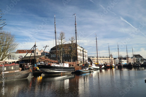 Obraz old museum harbor of Gouda with historic ships at mallegatsluis sluice to the Hollandsche IJssel in the Netherlands