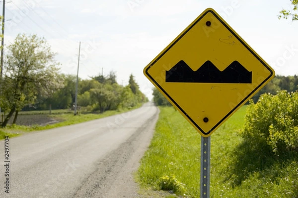 Fototapeta yellow caution sign warning bumpy road ahead