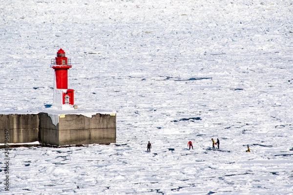 Fototapeta 冬の知床・ウトロ　ウトロ灯台の下での流氷ウォーク　オホーツク海の流氷の上を歩くアクティビティ（北海道・斜里町・ウトロ）