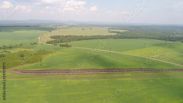 Fototapeta panoramic picture of green valley, fields and forest made by dron from high flight