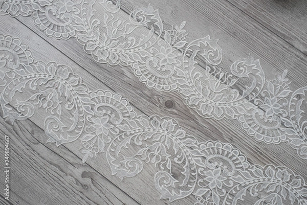 Fototapeta wooden background with spring flowers roses and lace ribbon. Happy womans day. The texture of lace on wooden background.