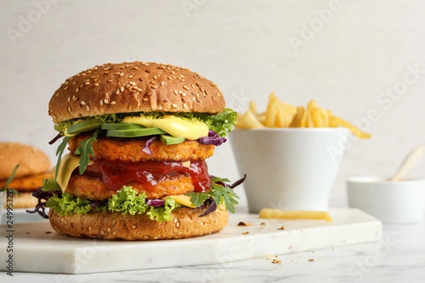 Fototapeta Vegan burger with carrot patties served on table against light background. Space for text