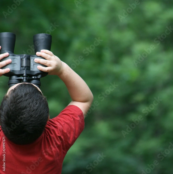 Obraz boy looking through binoculars in forest